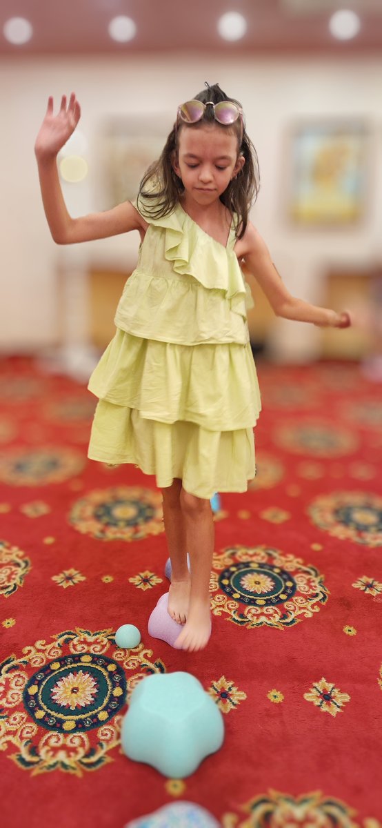 Момиче балансира на сензорни обекти по време на терапия